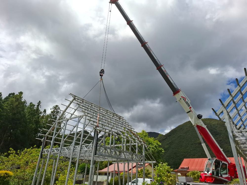 Grue mobile posant une charpente métallique